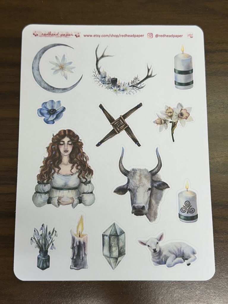 A sheet of stickers portraying St. Brigid, a white bull, St. Brigid's cross, candles, crystals, spring flowers